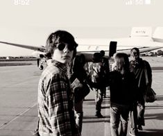 black and white photograph of people walking towards an airplane