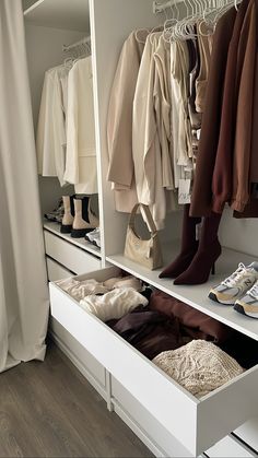 an organized closet with white drawers and shoes