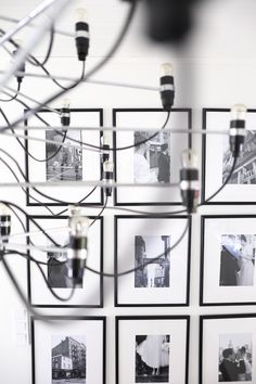 several black and white photographs hanging on a wall with wires attached to the sides of them