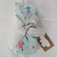 a small gift wrapped in fabric with a tag on the front and back of it