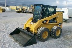 a yellow skid steer parked in a parking lot