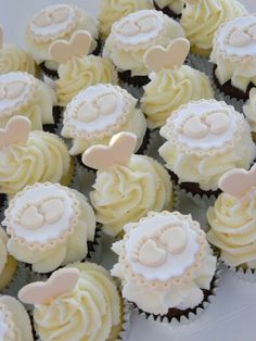 cupcakes with white frosting and pink decorations