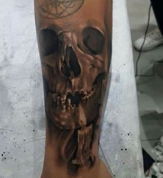 a man's arm with a skull tattoo on it