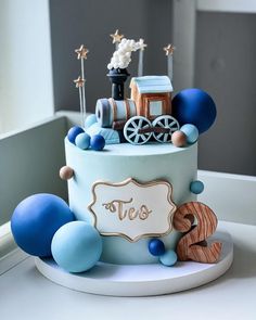 a blue and white birthday cake with train decorations