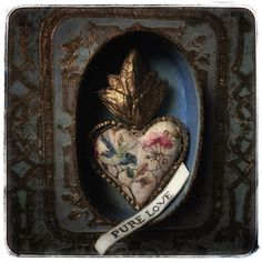 a heart shaped box with a ribbon in the shape of a leaf and words on it