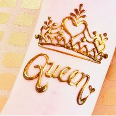 the word queen is written in gold on a white paper with a crown and heart