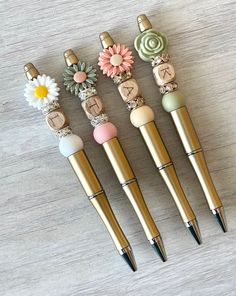 four pens with different designs on them sitting next to each other in front of a wooden table