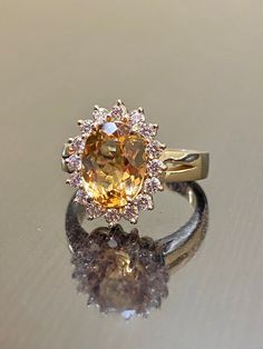 DeKara Designs Classic Metal- 14K Yellow Gold, .583. Stones- 1 Oval Imperial Topaz 3.50 Carats, 16 Round Diamonds G Color VS1 Clarity 0.55 Carats. Size- Choose Your Size, from 4-12. Please allow three to five working days for me to ship out your ring. I will start on making your ring as soon as transaction has been processed. Classic 14K yellow gold Art Deco influenced halo Imperial Topaz diamond engagement ring. The center stone is a whopping prong set 3.15 fiery oval shaped Peach colored beaut Vintage Topaz Engagement Rings, Yellow Topaz Ring Designs, Yellow Topaz Engagement Ring, Imperial Topaz Engagement Ring, Topaz Engagement Ring Yellow, Cartier Wedding Rings, Imperial Topaz Ring, Yellow Topaz Ring, Yellow Stone Rings