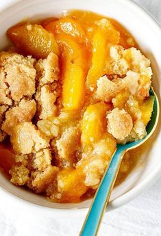 a close up of a bowl of food with a spoon on a cloth tablecloth