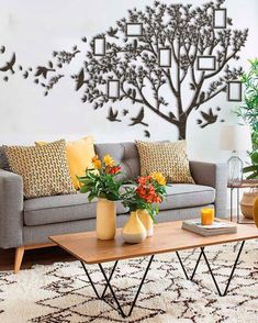 a living room with a couch, coffee table and tree wall decal