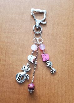 a close up of a key chain on a wooden surface with charms attached to it