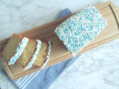 two slices of cake on a wooden cutting board with blue and white sprinkles