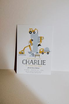 a card with construction vehicles on it and the words charlie written in black ink