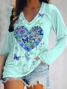 a woman wearing a blue shirt with butterflies on it