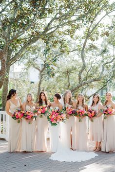 a bride and her bridals posing in front of the trees at their wedding