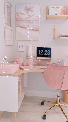 a desk with a pink chair and pictures on the wall