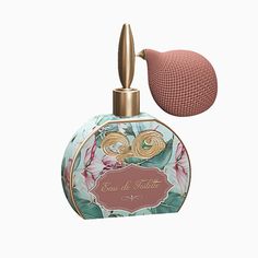 a bottle of perfume next to a pink ball on a white background with a gold top