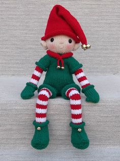 an elf doll sitting on the ground wearing green and red striped socks, with text christmas elf