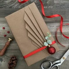 a bunch of brown paper sitting on top of a table next to scissors and ribbon