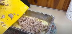 a pan filled with food sitting on top of a counter next to a yellow sign