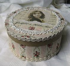 an old fashioned box with a picture on it's lid sitting on a white sheet