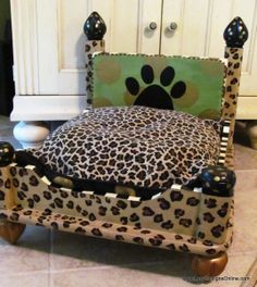 a leopard print dog bed with paw prints on the headboard and footrests