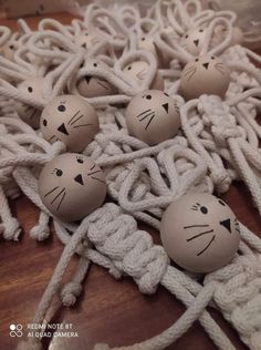 several wooden balls with faces on them sitting on a rope covered table top next to ropes