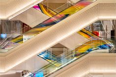 an overhead view of some stairs with colorful glass railings in the center and bottom