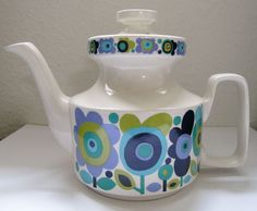 a tea pot with flowers painted on it