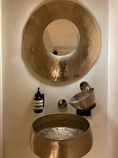 a bathroom with a sink, mirror and soap dispenser on the wall