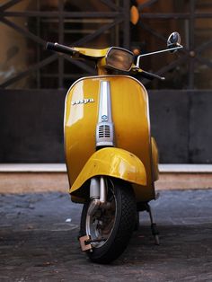 a yellow scooter parked in front of a building