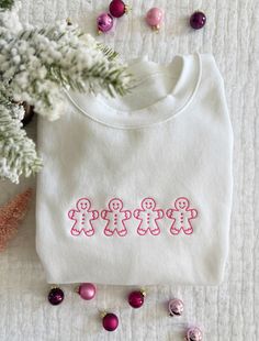 a white shirt with the word happy on it next to ornaments and a christmas tree