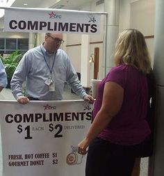 two men and a woman standing behind a table with a sign that says compliments $ 1 each