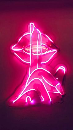 a pink neon sign with a woman's face in the center and eyes on it