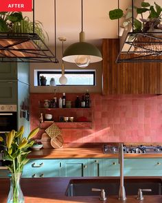 a kitchen with green cabinets and pink tile backsplash, potted plants on the counter