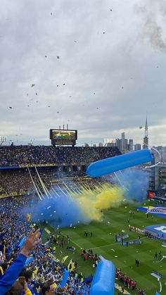 a stadium filled with lots of blue and yellow confetti flying in the air