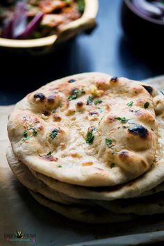 a stack of pita bread sitting on top of a wooden table