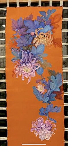 an orange banner with blue and purple flowers on it