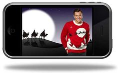 a cell phone with an image of a man in a red sweater and camels on the screen