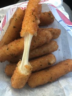 a pile of fried food sitting on top of a piece of paper covered in sauce