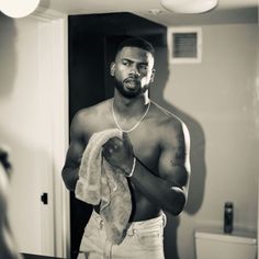 a man is standing in the bathroom with his shirt open