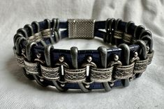 This rugged unisex bracelet looks great on just about anybody! This piece is handmade of sapphire blue embossed strap leather, silver chain, silver leather cord and finished with a metallic clasp for easy on and off. Fits a size 6.5 inch wrist snugly, but not tight.  Please note sizing! To measure your wrist, take a tape measure and wrap it snugly (with no slack) around your wrist. (I build in extra space for it to hang/fit properly.) If you have questions, please contact me! I'm happy to make a custom size for you. Handmade Leather Silver Bracelets, Handmade Leather Silver Bracelet, Handmade Silver Leather Bracelets, Unique Silver Leather Bracelet, Silver Metal Bracelets With Leather Strap, Nickel-free Silver Leather Bracelets, Silver Bracelets With Leather Strap, Hand-tooled Silver Leather Jewelry, Bohemian Silver Leather Bracelet