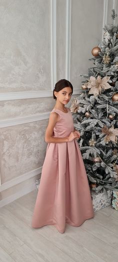 Introducing the enchanting Brookelle Satin Tulle Pageant Dress for Girls from Blush Kids - a masterpiece that embodies elegance and grace in every stitch. Crafted from premium quality satin, this exquisite dress features a chic tank top style bodice that gently caresses your princess's form, leading to an alluring plunging deep V backline that adds a dash of sophistication and charm. At the waist, a tastefully placed bow accentuates the silhouette, providing an impeccable fusion of style and swe Elegant Pink Satin Princess Dress, Pink Princess Dress For Confirmation, Pink Sleeveless Princess Dress For Formal Occasions, Sleeveless Pink Princess Dress For Formal Occasions, Elegant Sleeveless Gown For Confirmation, Gown For Kids, Chic Tank Tops, Girls Communion Dresses, Girls Crown