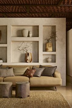 a living room filled with furniture and lots of shelves on the wall above it's couch