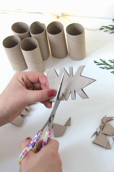 someone is cutting out some paper snowflakes