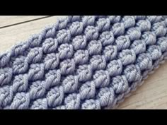 a blue and white knitted rug on top of a wooden floor