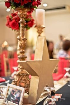 a table topped with a star next to two candles and pictures on top of it