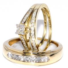 two gold wedding rings with diamonds on each one and an engagement ring in the middle