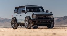 an off - road vehicle is parked in the desert