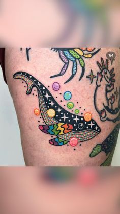 a woman's thigh with colorful tattoos on it